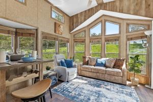 uma sala de estar com um sofá, cadeiras e janelas em Quail Run Farm- Rustic Tiny Home 3 em Chattanooga