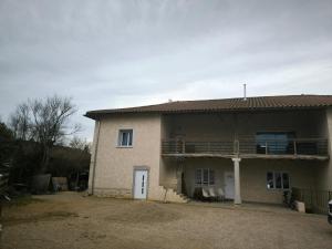 a house with a balcony on the side of it at Havre de paix près de Pérouges, charme et confort in Faramans