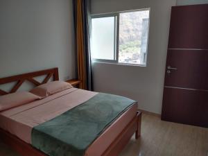 a bedroom with a large bed and a window at Ladeira apartamentos in Ribeira Grande