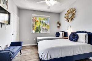 a bedroom with two beds and a blue chair at New 3bedroom 2 Bath condo with water view, walking to the beach in Hallandale Beach +93 photos