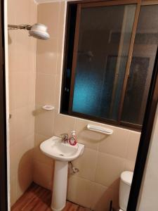 Un baño con lavabo, espejo e inodoro. en Departamento privado artístico, en La Paz