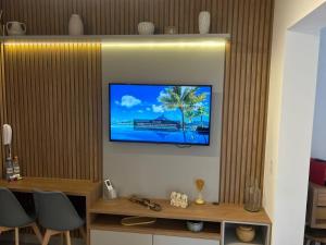 un salon avec une télévision sur un mur dans l'établissement Studio/SP/Hospital Santa Casa/ Higienópolis/is, à São Paulo
