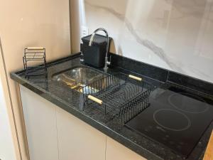 - un plan de travail noir avec évier dans la cuisine dans l'établissement Studio/SP/Hospital Santa Casa/ Higienópolis/is, à São Paulo