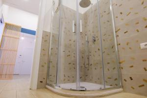 a shower in a room with a stone wall at Relais Palazzo Nizza - Luxotel & Apartotel in Salerno +42 photos