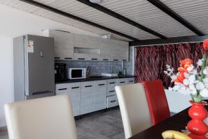 a kitchen with a table and chairs and a refrigerator at Magia Muntelui in Rîmeţi +31 photos