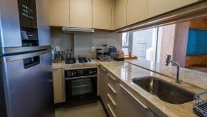 een keuken met een roestvrijstalen koelkast en een spoelbak bij Casa de luxo pé na areia na Praia Marceneiro em Milagres in São Miguel dos Milagres