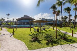 een park met een gebouw en palmbomen bij Casa de luxo pé na areia na Praia Marceneiro em Milagres in São Miguel dos Milagres
