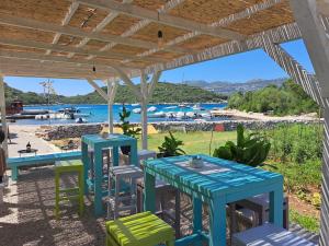 a patio with tables and chairs and a view of the water at Holiday home Villa Kastel in Korčula