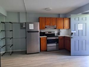 a kitchen with wooden cabinets and a refrigerator at Honu Waikiki by ALOH in Honolulu