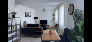a living room with a couch and a table at Maison flanc de coteau in Turquant