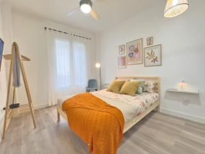 a bedroom with a bed with an orange blanket at Cadizz- Estudio Las Flores in El Puerto de Santa María