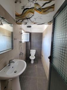 a bathroom with a sink and a toilet at Te Geri Hotel&PizzaBar in Ksamil