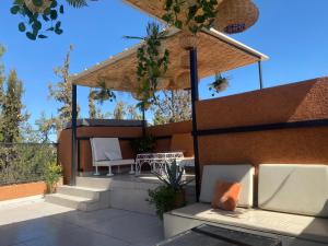 a patio with two white chairs and a table at Riad Lyna in Marrakesh