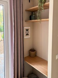 a shelf with a curtain next to a window at Casa Mundo in Nunspeet