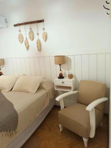 a bedroom with a bed and a chair at Dos Ambientes Deluxe Concordia Centro in Concordia +18 photos
