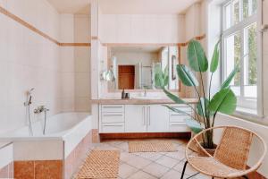 a bathroom with a tub and a sink and a plant at 3-Zimmer-Wohnung "Strandgeflüster" direkt am Strand in Travemünde in Travemünde +48 photos