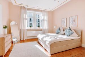 a bedroom with a bed and a dresser and a window at 3-Zimmer-Wohnung "Strandgeflüster" direkt am Strand in Travemünde in Travemünde