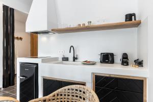 a kitchen with a black and white counter and a sink at Flèria Seaview Suites in Naxos Chora +67 photos