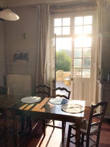a dining room with a table and chairs and a window at Maison du Gave in Sauveterre +40 photos