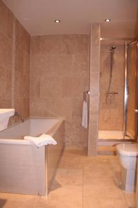 a bathroom with a tub and a toilet and a shower at Advocate Arms in Market Rasen