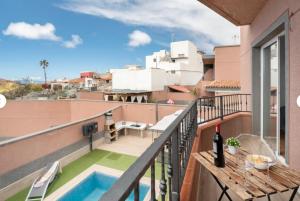 a balcony with a table and a swimming pool at Villa TEJINA BEAUTIFUL in Guía de Isora