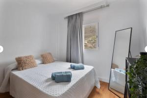 a white bedroom with a bed and a mirror at Villa TEJINA BEAUTIFUL in Guía de Isora +24 photos