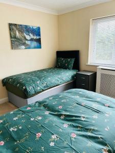 a bedroom with two twin beds and a picture on the wall at Marston moretaine Serviced Accommodation in Marston Moretaine