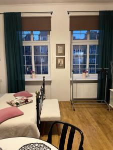 a bedroom with two beds and two windows at Apartament Piwna52 in Gdańsk