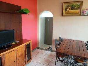 una sala da pranzo con tavolo in legno e TV di Linda casa de 2 Qtos completa com vista a Belo Horizonte Altre 4 foto