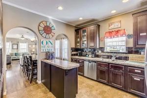 a large kitchen with wooden cabinets and a large island at Caribbean Palm 3BR Retreat King Bed Fireplace in Bolivar Peninsula