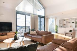 a living room with a couch and a television at Luxury Waterfront Stay in Launceston