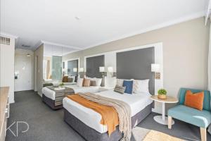 黄金海岸Bright Oceanview Apartment on Level 11, Mantra on View, Surfers Paradise的有两张床和一把椅子的酒店房间