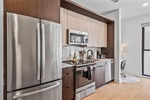 a kitchen with a stainless steel refrigerator and wooden cabinets at OTR 1 Bed Suite Free Parking Gym Pool Clubroom in Cincinnati