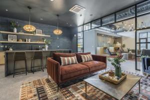 a living room with a brown couch and a bar at LUX Studio King Bed Free Parking Gym New in Pittsburgh