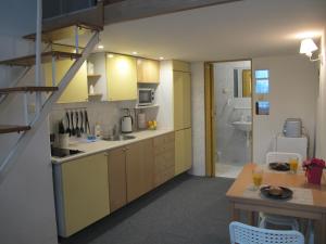 a kitchen with yellow cabinets and a sink and a table at Apartament Kazimierz Brzozowa in Krakow