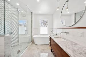 ein Badezimmer mit Badewanne, Waschbecken und Spiegel in der Unterkunft Modern Heritage in Heart Halifax in Halifax + 41 Fotos