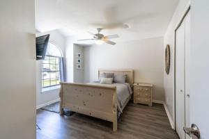 a bedroom with a bed and a ceiling fan at Beach Retreat with Backyard Flair and Yard Games in Atlantic Beach