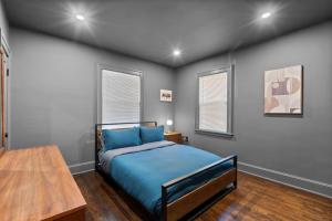 1 dormitorio con cama azul y mesa de madera en 28 - Modern Bungalow, en New Britain