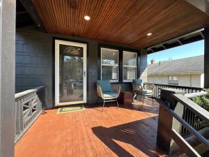 un porche cubierto con sillas en la cubierta en 28 - Modern Bungalow, en New Britain