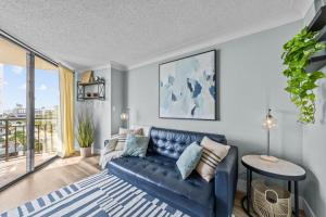 ein Wohnzimmer mit einer blauen Couch und einem großen Fenster in der Unterkunft Beachfront Fireplace Downtown Hot Tub King Bed in Myrtle Beach + 29 Fotos