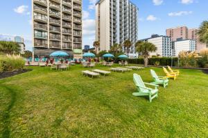 eine Gruppe von Stühlen und Tischen in einem Park mit Gebäuden in der Unterkunft Beachfront Fireplace Downtown Hot Tub King Bed in Myrtle Beach