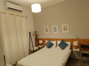 a bedroom with a white bed with blue pillows at 'ESTRELA STAYS' in Lagos