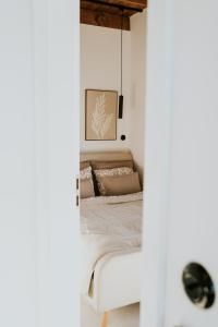 ein Schlafzimmer mit einem Bett in einem weißen Raum in der Unterkunft Kamienna Azyl - domek z sauną i balią, Kotlina Kłodzka in Kamienna + 35 Fotos