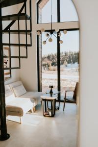 ein Wohnzimmer mit großem Fenster und Tisch in der Unterkunft Kamienna Azyl - domek z sauną i balią, Kotlina Kłodzka in Kamienna