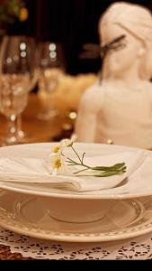 ein weißer Teller mit einer Blume auf dem Tisch in der Unterkunft Casa Luxo p 12 pessoas ou Suite Premium 4 pessoas com jacuzzi in Campos do Jordão