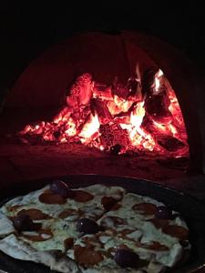 eine Pizza vor einem Feuerofen in der Unterkunft Casa Luxo p 12 pessoas ou Suite Premium 4 pessoas com jacuzzi in Campos do Jordão + 58 Fotos