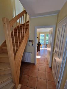 a hallway with a wooden staircase and aoyer with a table at Ferienhaus Seemöwe mit Deichblick Butjadingen-Burhave in Burhave