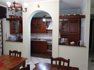 an archway in a kitchen with wooden cabinets at Kalimèra B&B in Capriglia