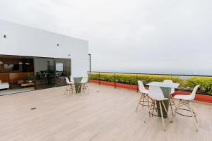 a balcony with tables and chairs and a view of the ocean at Cielo 404 in San Salvador