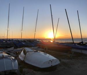 a group of boats parked on the beach with the sunset at Iris Cottage in Whitstable